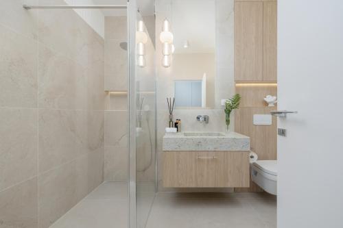 bagno con lavandino e doccia in vetro di Wave Międzyzdroje Luxury Apartment MORENORENT a Międzyzdroje