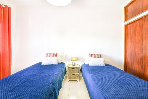 two beds sitting next to each other in a bedroom at Casa dos Avós in Albufeira