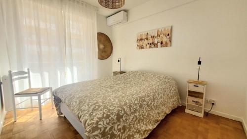 une chambre avec un lit, une chaise et une fenêtre dans l'établissement Appartement centre ville & plage, à Antibes