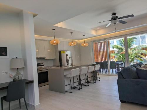 a kitchen and living room with a bar with stools at Dolphin Villa #09 in West Bay