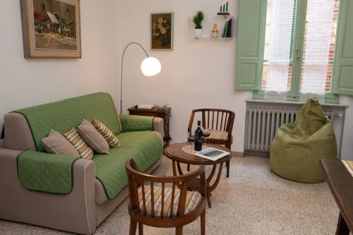 uma sala de estar com um sofá verde e uma mesa em Casa di Lara - Nel cuore della città em Montepulciano