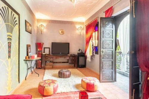 een woonkamer met een tv en een deur bij Riad Osawa in Marrakesh