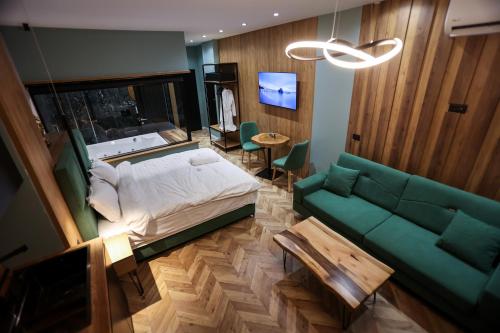 um quarto com uma cama e um sofá verde em B.G Luxury Suites em Korçë