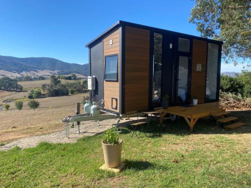 a tiny house sitting on top of a field at Nichol Road Hideaway at Annies Retreat by Tiny Away in Yackandandah