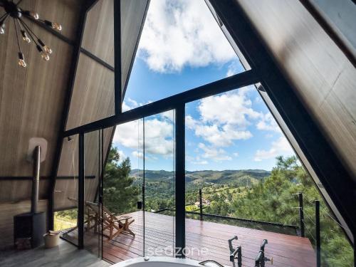 a bathroom with a large window with a view at Chales Naturale - Campos do Jordão - CNA in Campos do Jordão