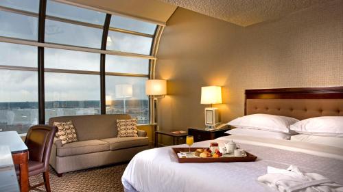 a hotel room with a bed and a chair at Sheraton Hotel Denver Tech Center in Greenwood Village