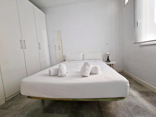 a white bedroom with a large white bed with white pillows at San Buenaventura Vistillas apartamento para dos in Madrid