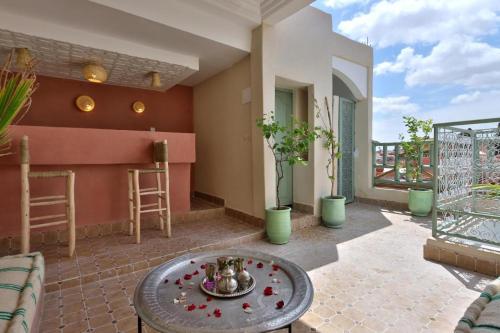 a patio with a table and a balcony at Riad Osawa in Marrakesh