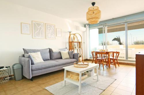 un salon avec un canapé et une table dans l'établissement Appartement Gradus - Welkeys, à Palavas-les-Flots