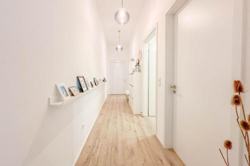 a hallway with white walls and a wooden floor at Modernes Trierer CityLoft mit großem Balkon in Trier