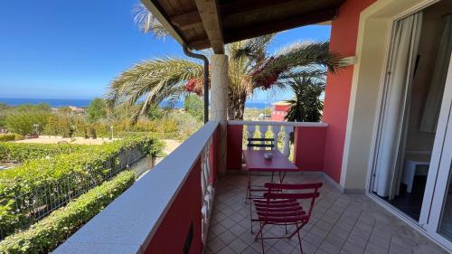 a balcony of a house with two chairs and the ocean at Borgo di Santa Barbara in Santa Domenica