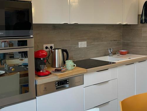 une cuisine avec des armoires blanches et un comptoir dans l'établissement Un appartement contemporain en centre-ville, à La Seyne-sur-Mer