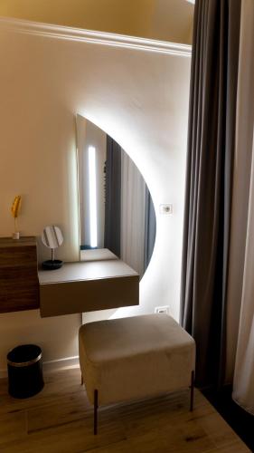a dressing room with a mirror and a ottoman at Notti d'Autore Suites in Catania