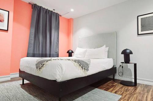 een slaapkamer met een bed met een oranje muur bij The Lofts on Clematis 404 Downtown West Palm Beach in West Palm Beach
