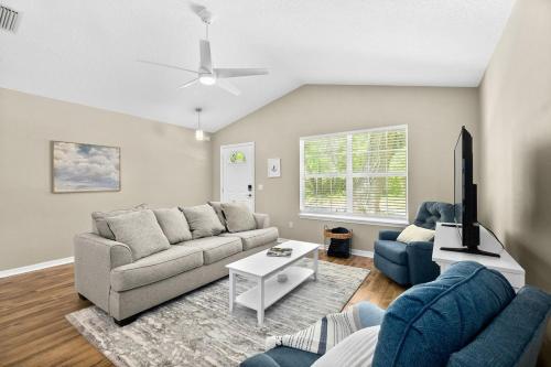 a living room with a couch and a tv at Peaceful Pearl Retreat- 5 Minutes to Downtown, 10 Minutes to Beach in St. Augustine