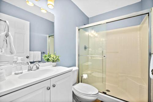 a bathroom with a toilet and a glass shower at Peaceful Pearl Retreat- 5 Minutes to Downtown, 10 Minutes to Beach in Saint Augustine