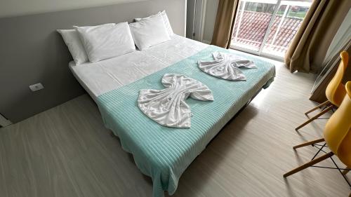 um quarto com uma cama com toalhas em 06-Studio encantador em Curitiba em Curitiba