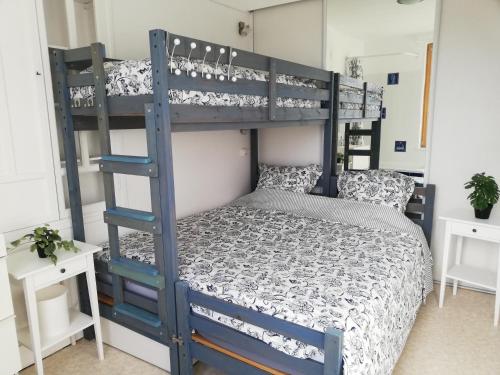 - une chambre avec un lit superposé avec une échelle bleue dans l'établissement Petit appartement en bord 2 mer., à Veules-les-Roses