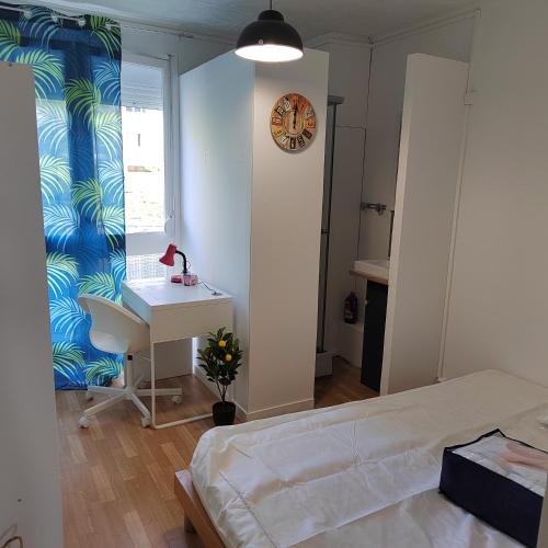 - une chambre avec un lit, un bureau et une horloge dans l'établissement Chambre d'hôtes appartement en colocation, à Rennes