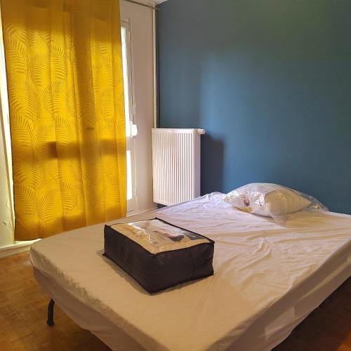 um saco sentado em cima de uma cama num quarto em Chambre d'hôtes appartement en colocation em Rennes
