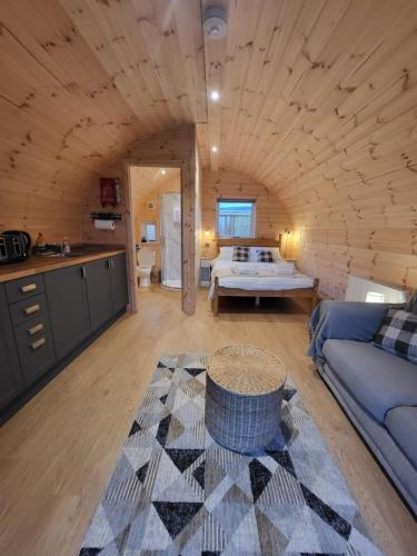 a living room with a bed in a log cabin at Lois' Pod with Hot Tub, Near Airport in Bristol