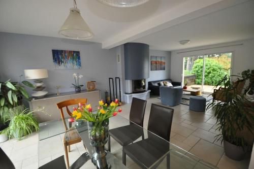 ein Wohnzimmer mit einem Glastisch mit Blumen darauf in der Unterkunft Maison à la campagne proche Disney in Couilly-Pont-aux-Dames