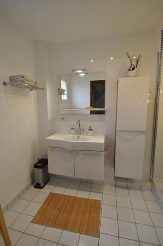 La salle de bains blanche est pourvue d'un évier et d'un réfrigérateur. dans l'établissement Maison à la campagne proche Disney, à Couilly-Pont-aux-Dames