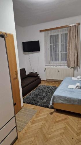 a bedroom with a bed and a couch and a window at Eisenerzer Apartments - Radmeisterhaus in Eisenerz