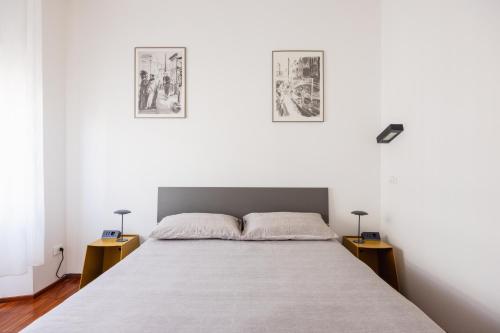 a bedroom with a bed and two pictures on the wall at Memo Apartment in Bologna