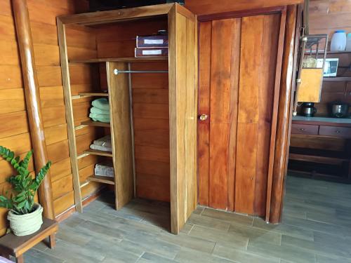 a closet with wooden walls and a wooden door at Cabaña Rincón de Curubandé in Liberia