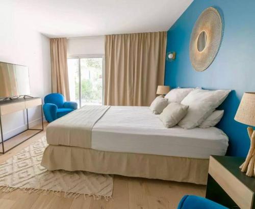 une chambre avec un grand lit et un mur bleu dans l'établissement Villa JFK, à Marseille