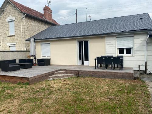 une terrasse avec une table et des chaises ainsi qu'une maison dans l'établissement Maison lea, à Caen