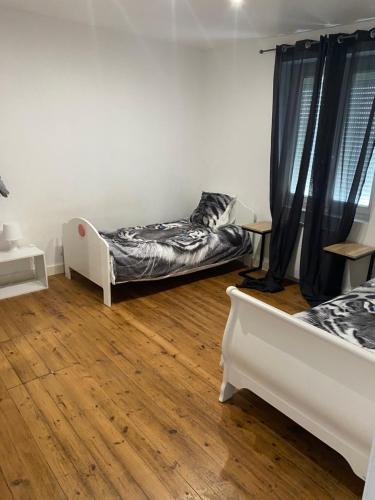 Cette chambre dispose de deux lits et de parquet. dans l'établissement Maison lea, à Caen