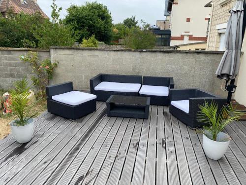 un patio avec deux canapés, une table et des chaises dans l'établissement Maison lea, à Caen