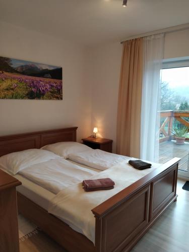 um quarto com uma cama grande e uma janela em Leśny Domek 