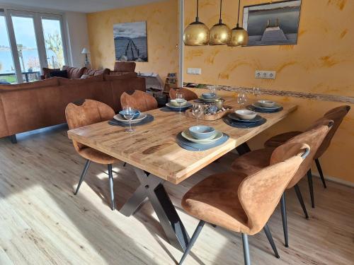 a dining room with a wooden table and chairs at Wierhooft 21 in Den Oever