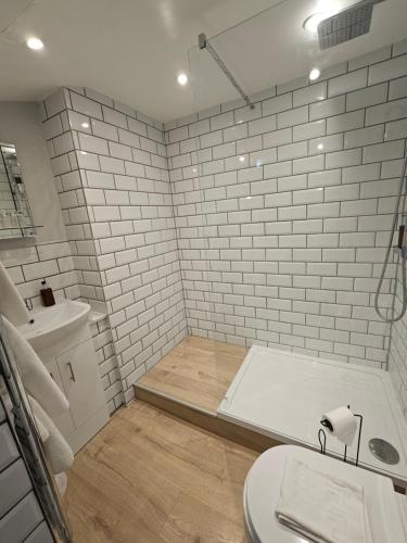 Baño blanco con aseo y lavamanos en The Beacons Guest House, en Brecon