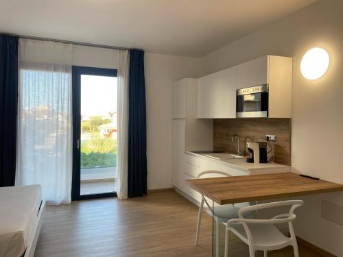 a kitchen with a table and chairs in a room at Residence Cala Bianca in Porto Torres