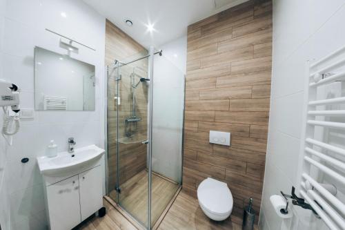 uma casa de banho com um chuveiro, um WC e um lavatório. em Apartamenty Kajetany 3Rooms em Kajetany