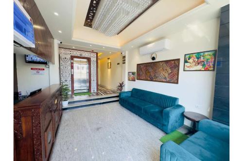 a living room with a blue couch and a tv at Hotel Jaipur Dreams in Jaipur