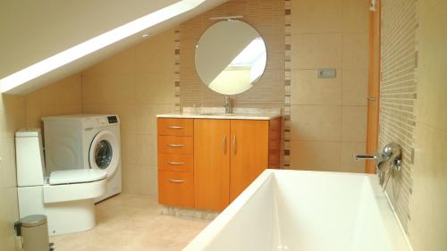 y baño con bañera, lavabo y lavadora. en Apartamentos Casa Cabana, en Cambados