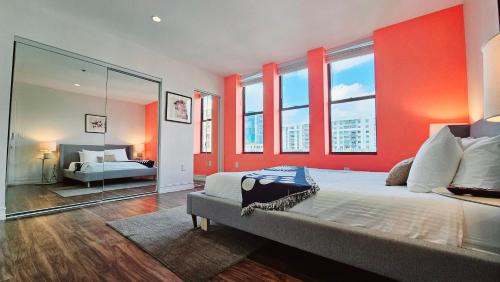 een slaapkamer met rode muren en een bed met een spiegel bij The Lofts on Clematis 402 Downtown West Palm Beach in West Palm Beach