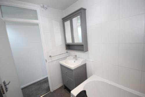 a white bathroom with a sink and a mirror at Lee's Lodge - Modern 2 Bedrooms in Hillingdon