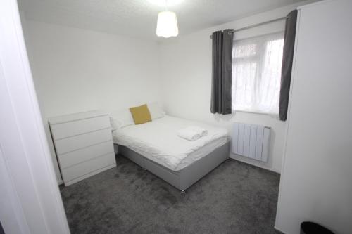 een kleine slaapkamer met een bed en een raam bij Lee's Lodge - Modern 2 Bedrooms in Hillingdon