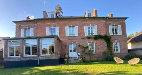 a brick house with two chairs in front of it at MAISON 54 in Bernay