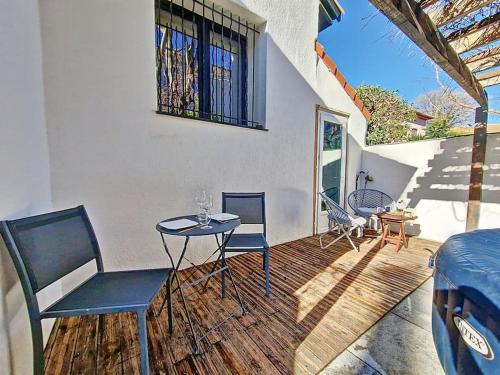 eine Terrasse mit einem Tisch, Stühlen und einem Fenster in der Unterkunft Cosy Tiny centre-ville de Nîmes in Nîmes