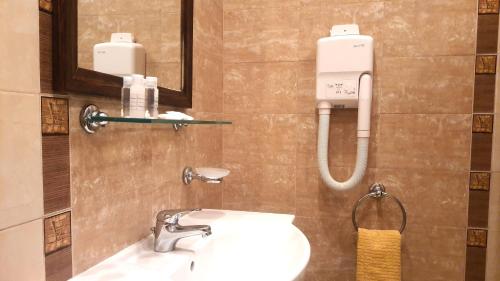 a bathroom with a sink and a mirror and a toilet at Santa Marina Holiday Village - Purple Harmony Sea view in Sozopol