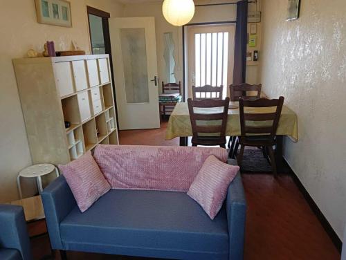 Una sala de estar con un sofá y una mesa con sillas. en Gîte à Châtelus, au calme dans l'Allier, en Châtelus