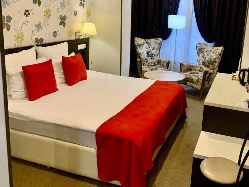 ein Hotelzimmer mit einem Bett mit roten Kissen in der Unterkunft East Gate Boutique Hotel in Tbilisi City