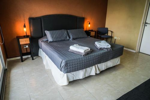 1 dormitorio con 1 cama con 2 toallas en Atardeceres Apartments en Cañuelas